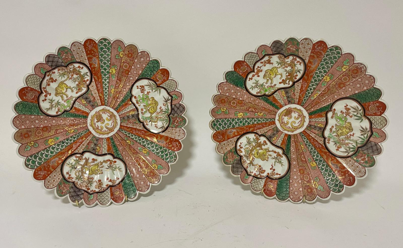 A pair of Japanese porcelain chargers with panelled decoration, scalloped rims, 12" diameter (2)