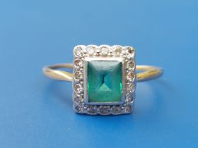 A rectangular emerald & diamond cluster ring on (mis-shapen) yellow metal shank. Finger size V -