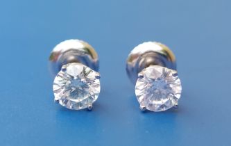 A pair of diamond stud earrings, each four-claw set brilliant weighing approximately 0.50 carat in