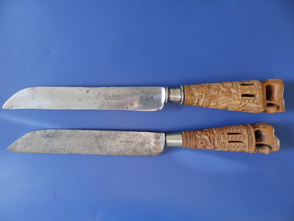 Two 19thC Dutch table knives, having bold tapering carved wooden handles, each surmounted by two