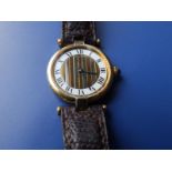 A ladies gold plated Cartier wrist watch, having striped dial centre, Roman numerals on white