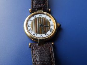 A ladies gold plated Cartier wrist watch, having striped dial centre, Roman numerals on white
