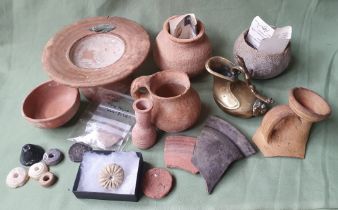 A collection of ancient pottery and artefacts including Roman ceramics, Mesopotamian stone jar and