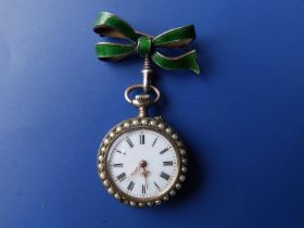 A ladies green enamelled silver fob watch with pearl set borders, white enamel dial, the back