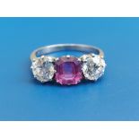 A three stone pink sapphire & diamond ring, the stepped rectangular cut sapphire flanked by claw-set