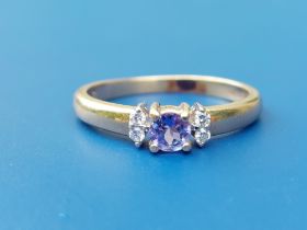 A small modern tanzanite & diamond set '14k' ring. Finger size 100-150.
