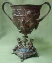 A silver plated goblet, decorated classical figures, enamelled base, 7" high.