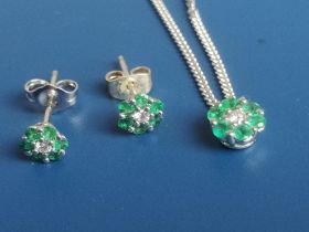 A small emerald & diamond 9ct white gold cluster pendant on chain and a matching pair of