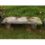 A 'stone' garden seat of low trestle table form, the supports with acanthus mouldings, 14" high, 48"