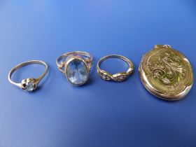 A 9ct oval locket, a 9ct gold aquamarine ring, a 9ct zircon ring and another set with cz