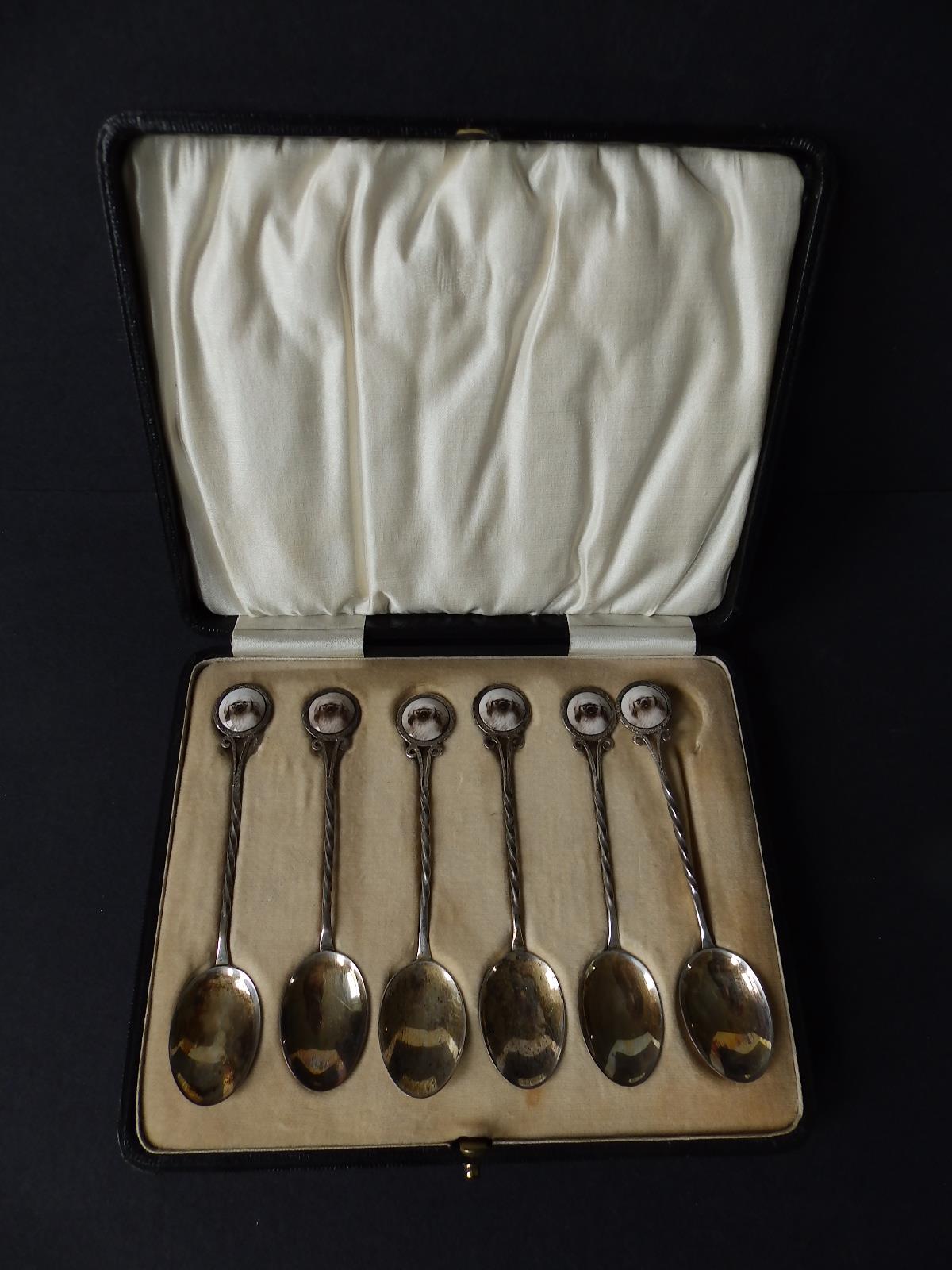 A cased set of six silver teaspoons, the handles inset with a colour printed cabochon portrait of