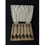 A cased set of six silver teaspoons, the handles inset with a colour printed cabochon portrait of