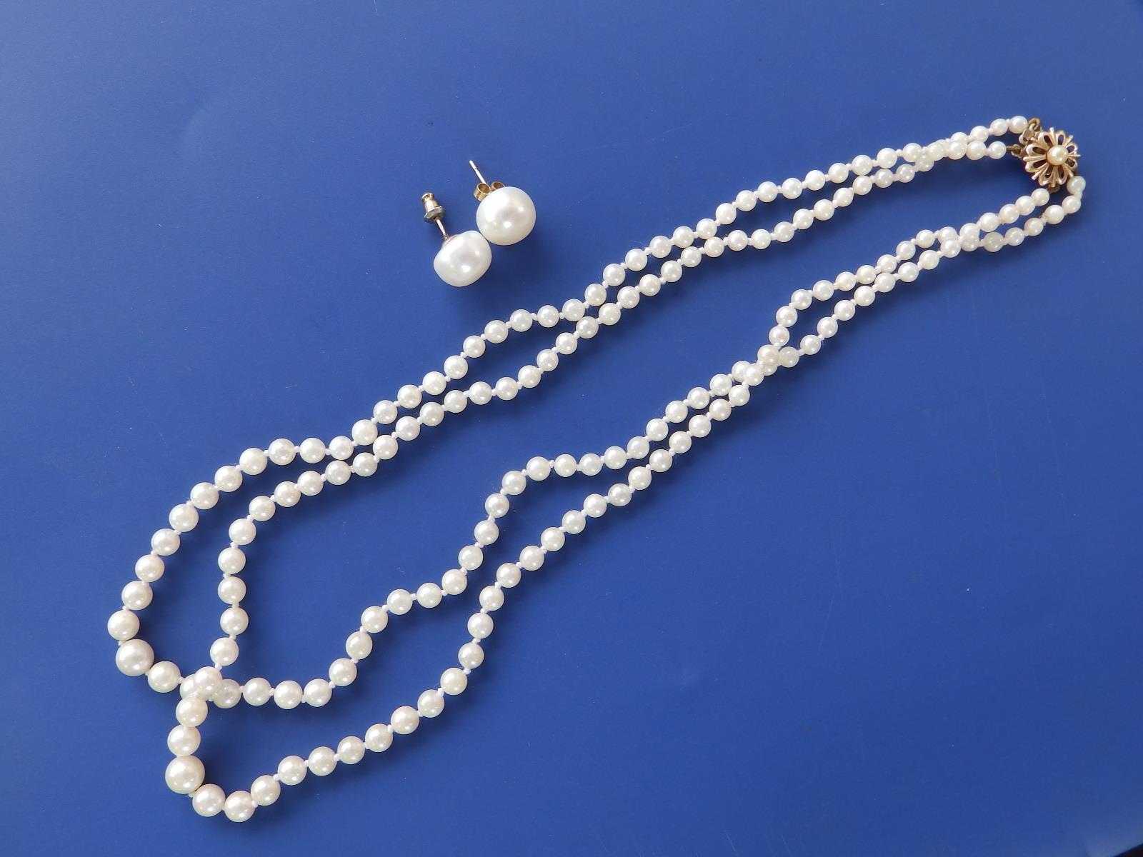 A graduated pearl twin strand necklace with yellow metal clasp and a pair of button pearl