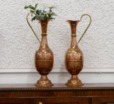 Matching pair of hand beaten copper and brass handled jugs,