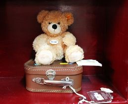 Cuddly soft Steiff bear "Fynn" with suitcase and tags