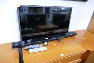 33" LG television with sound bar and remote controls