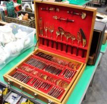 A canteen of brass or bronze cutlery with wooden handles