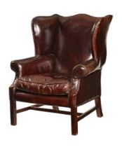 A Queen Anne style leather upholstered wing easy chair,