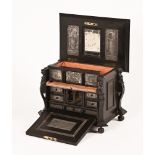 A Victorian ebonised cabinet, with carved figureheads to each side,