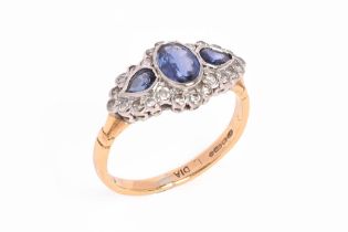An 18 ct gold sapphire and diamond ring, three sapphires with a surround of small diamonds.