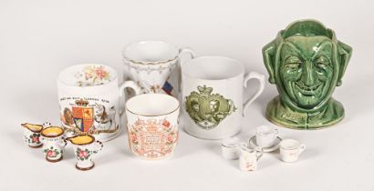 A collection of three commemorative mugs, a cup,