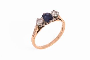 An 18 ct gold sapphire and diamond three stone ring. Size K/L.