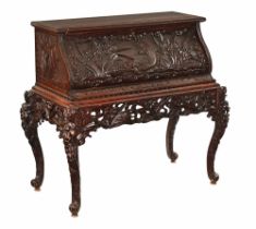 A Japanese carved wooden bureau, decorated with fish and plant life,