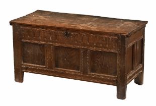 An antique oak coffer, with three panelled front and carved frieze raised on stile feet.