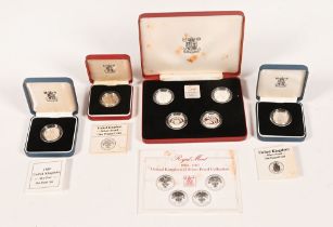 A Royal Mint 1984-1987 United Kingdom £1 silver proof collection, and three other cased proof coins.