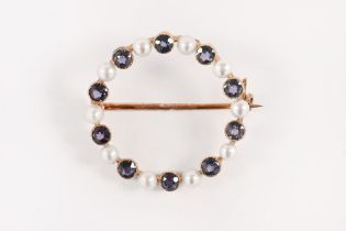 A 15 ct gold circular brooch, set with seed pearls and blue stones. Overall weight 3.4 grams.