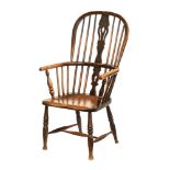 A Windsor armchair or typical form, raised on turned legs.