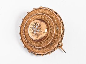 A gold coloured metal target shaped brooch, set with five small diamonds and with glass back,