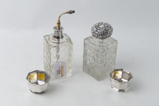 Two cut glass dressing table perfume bottles with silver caps, and pair of silver trinket pots,