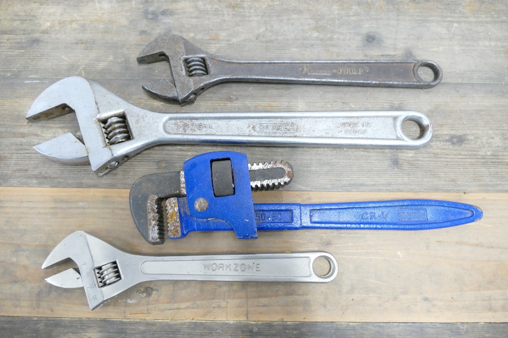 Three various sized monkey wrenches and adjustable pipe wrench.