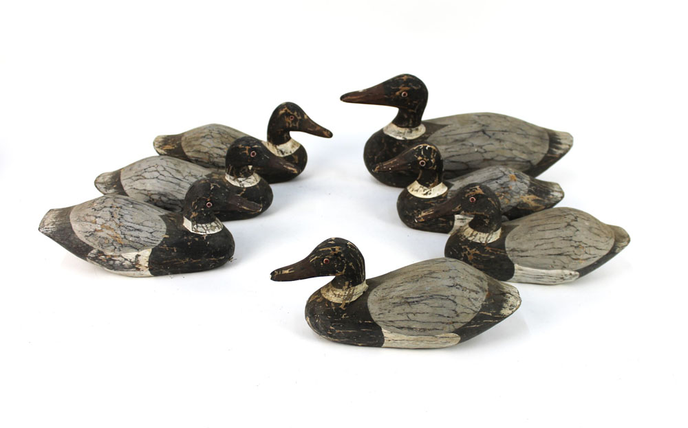 Seven late 20th century wooden duck decoys, in two different sizes, the largest beak to tail 37 cm,