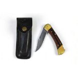 A buck 110 folding pocketknife, with a 3 3/4" blade, 22 cm overall with leather pouch.