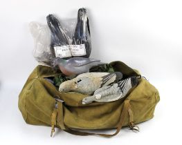 A vintage canvas duffle bag, containing a pigeon hide net, various crow and pigeon decoys.