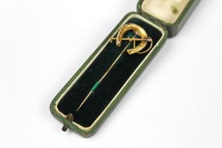 A Victorian/Edwardian gold coloured stock pin, with horseshoe and riding crop length +/- 6.