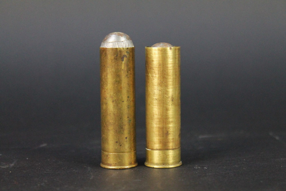 Two Kynoch 14 bore metallic shotgun cartridges, loaded with solid slugs.