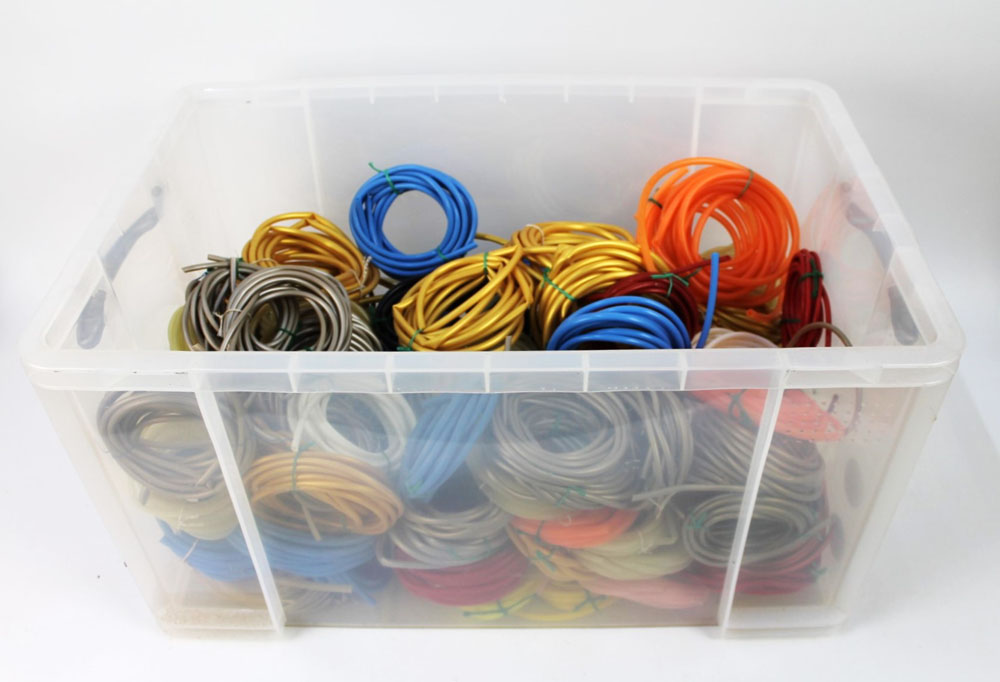 A large plastic box containing a quantity of Flying C rubber tubing.