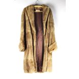 Taxidermy - A vintage Bullough Ltd muskrat fur coat, Length +/- 110 cm, armpit to armpit +/- 50 cm.