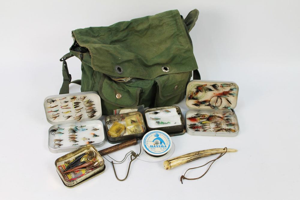 A vintage tackle bag containing two alloy fly boxes containing salmon flies,