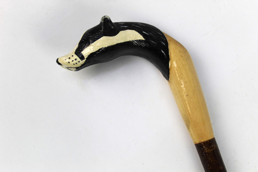 A walking stick with carved wooden handle in the form of a badger,
