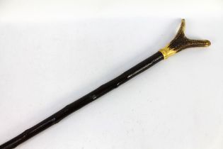 A walking stick with red stag antler handle. Overall length 124.5 cm.