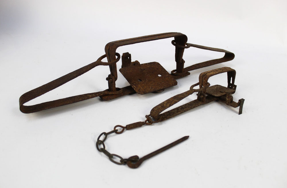 Two vintage traps, the first a gin trap length 18.5 cm, the second leg hold trap length 45 cm.