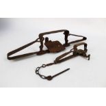 Two vintage traps, the first a gin trap length 18.5 cm, the second leg hold trap length 45 cm.