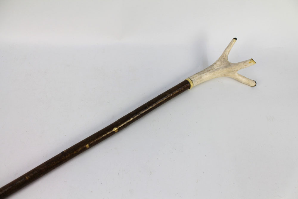 A walking stick with a red stag antler handle. Overall length +/- 140 cm.