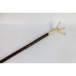 A walking stick with a red stag antler handle. Overall length +/- 140 cm.