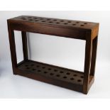 A large wooden stick stand, with 19 apertures. Height 57 cm, width 80 cm, depth 23 cm.