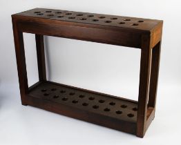 A large wooden stick stand, with 19 apertures. Height 57 cm, width 80 cm, depth 23 cm.